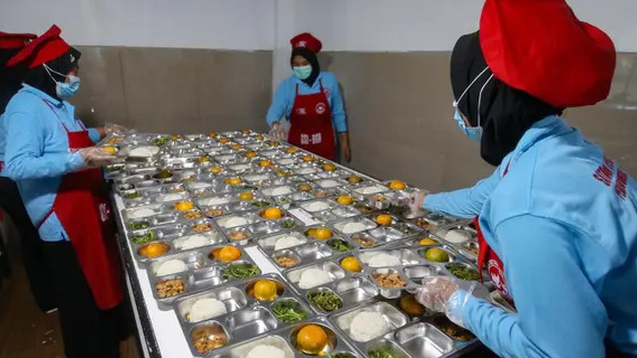 Pekerja menyiapkan Makanan Bergizi Gratis (MBG) di Dapur Makan Bergizi Gratis Kebayunan, Tapos, Depok, Jawa Barat, Senin (6/1/2025). (merdeka.com/Arie Basuki)