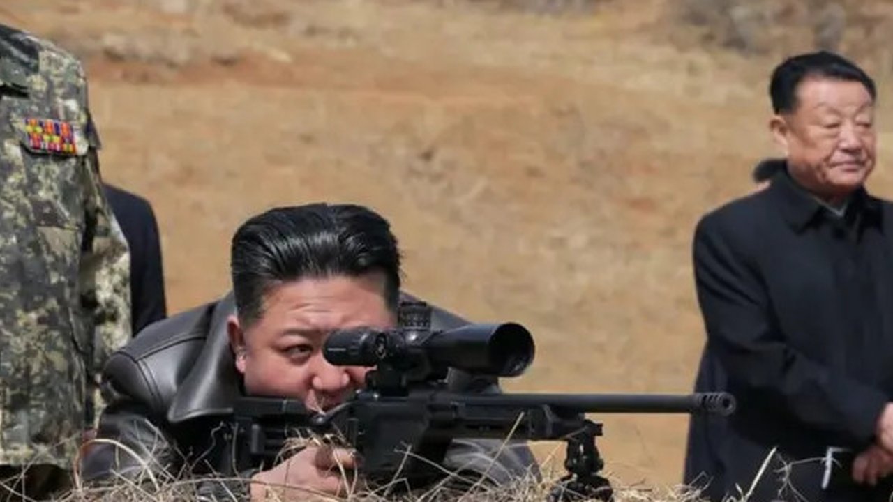 Pemimpin Korea Utara Kim Jong Un melihat melalui teropong senapan saat mengunjungi pangkalan pelatihan pasukan operasi khusus Tentara Rakyat Korea untuk mengamati sesi pelatihan komprehens
