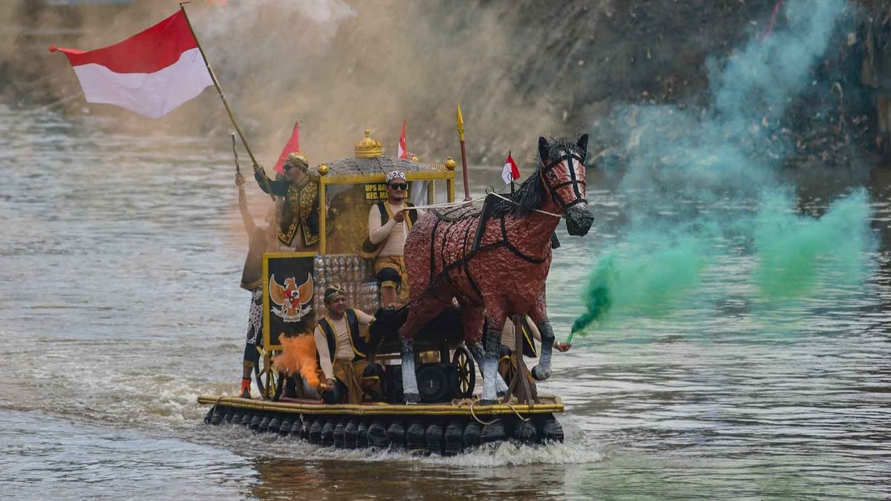 Peserta dengan perahu yang terbuat dari sampah daur ulang mengikuti Festival Perahu Cilung 2025 di Kali Ciliwung, Pancoran, Jakarta Selatan, Minggu (28/09/2025).