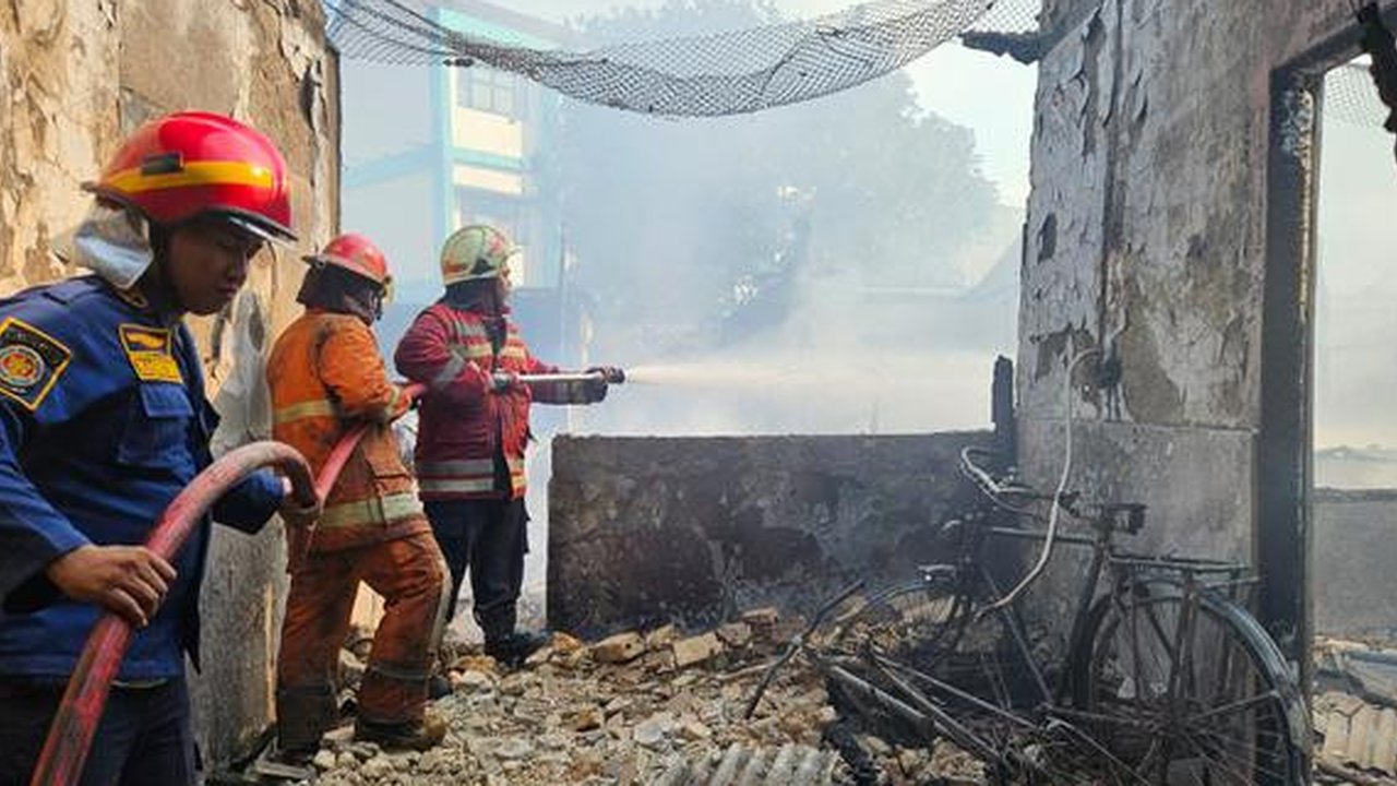 Petugas Pemadam Kebakakan memadamkan api yang membakar asrama polisi Polsek Serpong, Polres Tangerang Selatan. (Liputan6/Pramita Tristiawati)