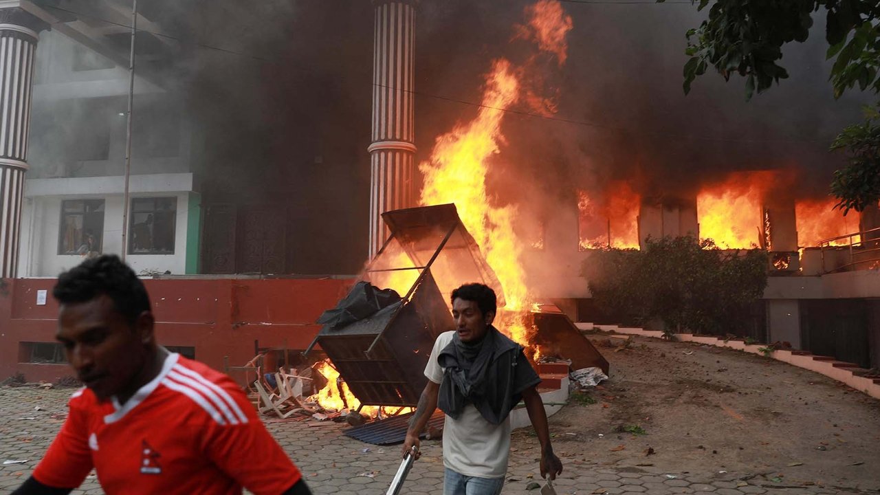 Para demonstran berkumpul di luar kantor Partai Kongres Nepal yang terbakar dalam aksi protes untuk mengecam tindakan keras polisi terhadap demonstran di Kathmandu, Selasa (9/09/2025).