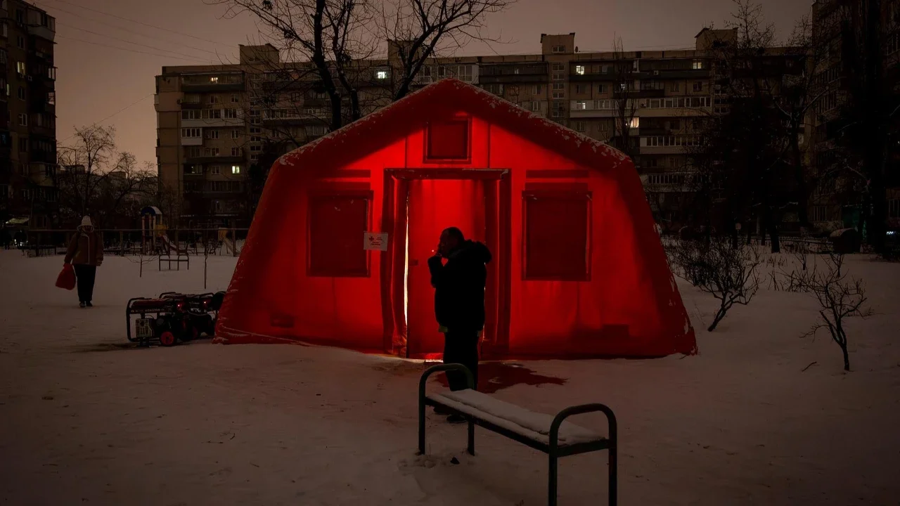 Warga  merokok  di  depan tenda darurat yang disediakan bagi warga setelah serangan udara Rusia terhadap fasilitas energi, yang menyebabkan pemadaman listrik, air, dan pemanas di tengah musim dingin di Kyiv, Ukraina, Selasa (13/01/2026).
