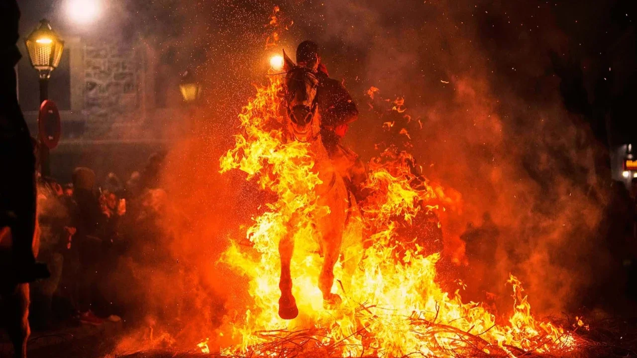 Para penunggang kuda melompati api unggun sebagai bagian dari ritual untuk menghormati Santo Antonius sang Abbas, santo pelindung hewan peliharaan, di San Bartolome de Pinares, Spanyol, Jumat (16/01/2026).