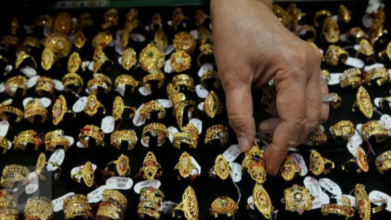 Seorang pelanggan memegang perhiasan emas selama festival Hindu 'Akshaya Tritiya', hari keberuntungan dalam kalender Hindu untuk membeli barang-barang berharga, di ruang pamer perhiasan di