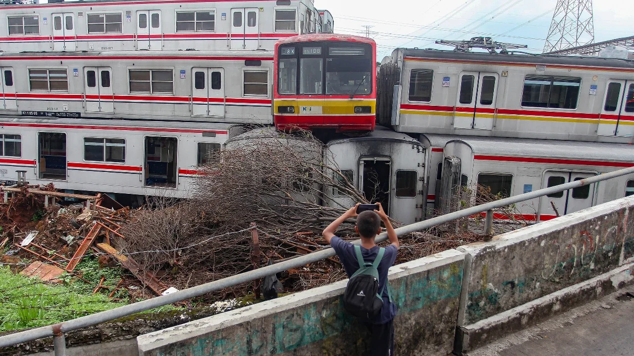 Seorang anak menyaksikan  tumpukan gerbong kereta rel listrik (KRL) bekas di Jalan Kampung Rawageni, Cipayung, Kota Depok, Selasa (20/01/2026).