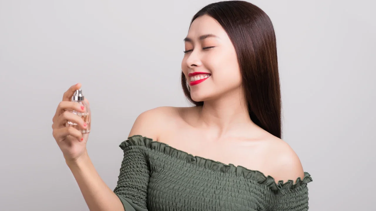 Ilustrasi perempuan menggunakan parfum.