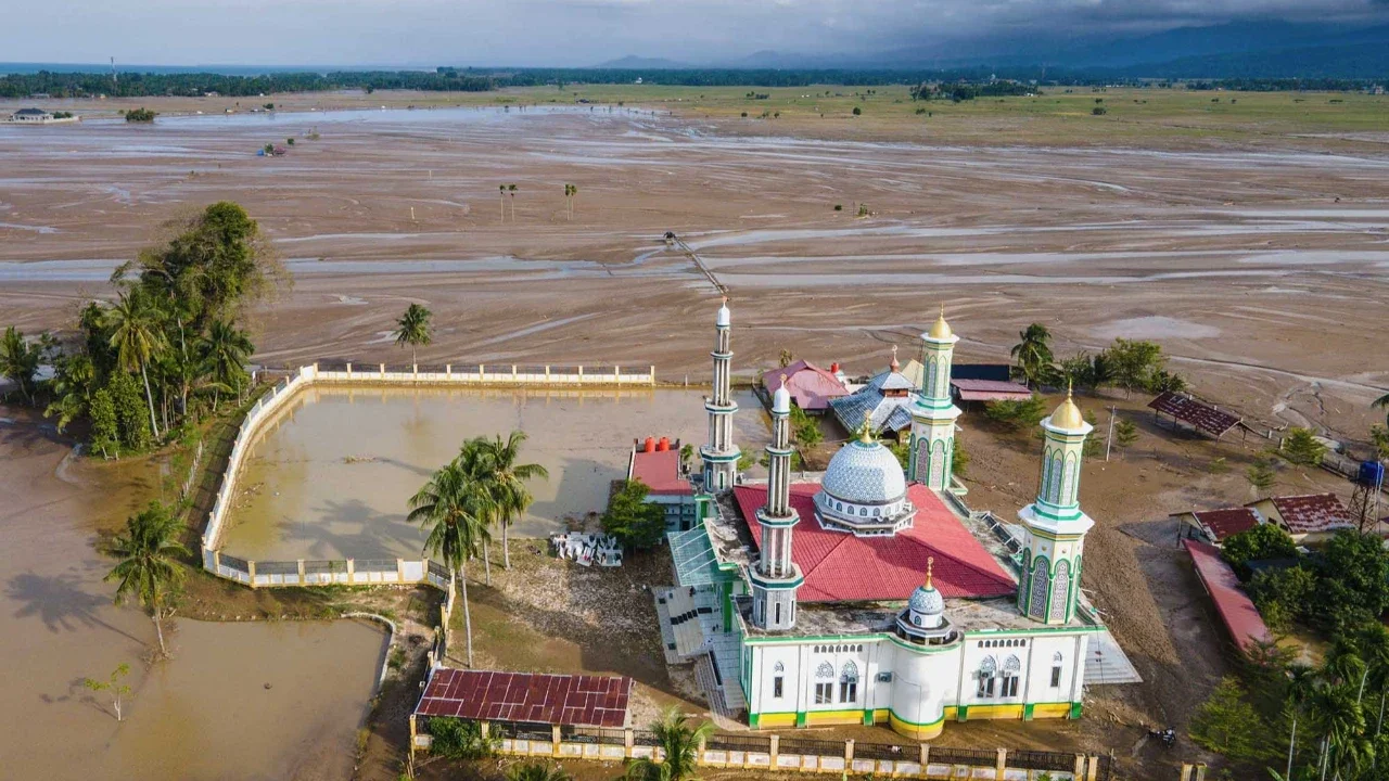Kendaraan  melewati sawah yang terendam lumpur setelah banjir bandang di Meureudu, Kabupaten Pidie Jaya, Provinsi Aceh, Senin (08/ 12/2025).