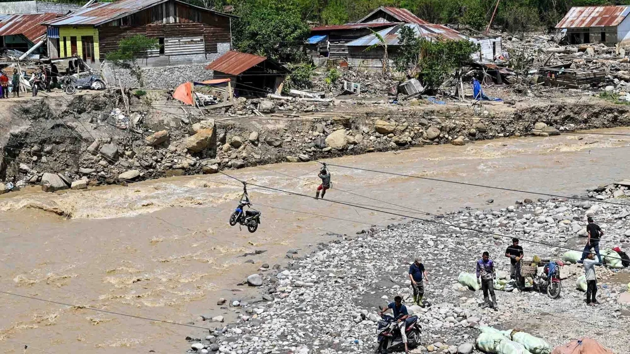 Warga menggunakan tali untuk menyeberangi sungai pascabanjir bandang di Ketol, Aceh, Selasa (06/01/2026).