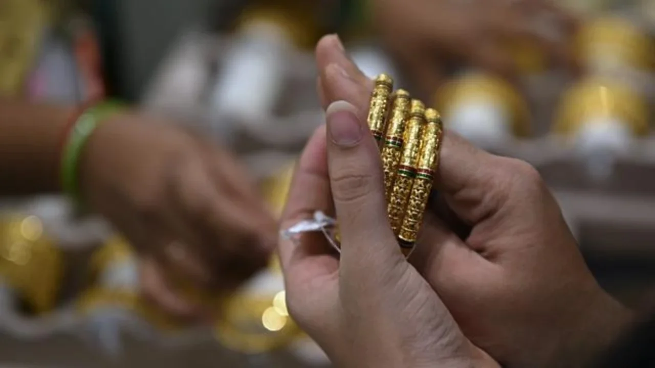 Seorang pelanggan mencoba gelang emas selama festival Hindu 'Akshaya Tritiya', hari keberuntungan dalam kalender Hindu untuk membeli barang-barang berharga, di ruang pamer perhiasan di Che