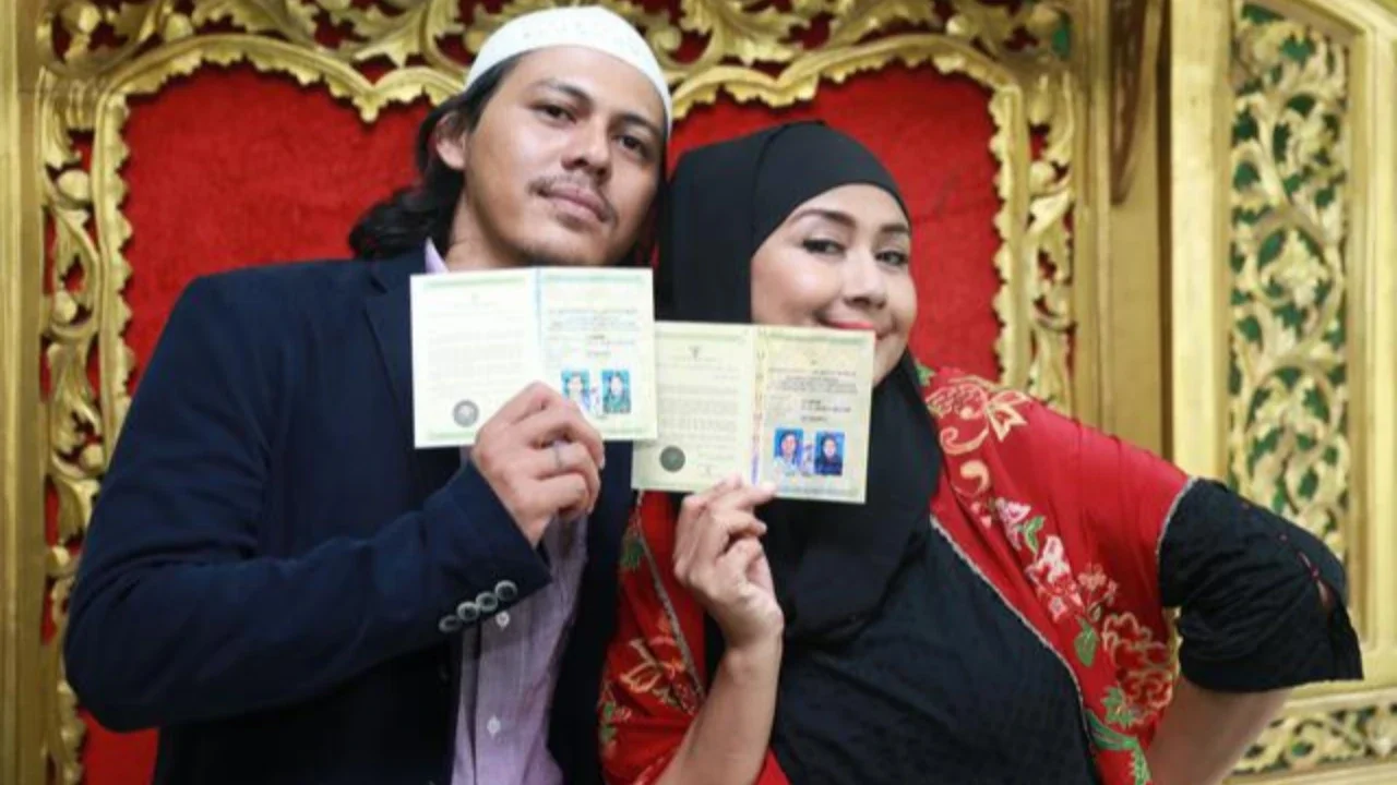 Sementara itu, Santi tampil memikat dalam balutan kebaya putih dengan detail bordir halus. Siluet kebaya yang ringan berpadu dengan kain bernuansa lembut, menghadirkan tampilan pengantin yang