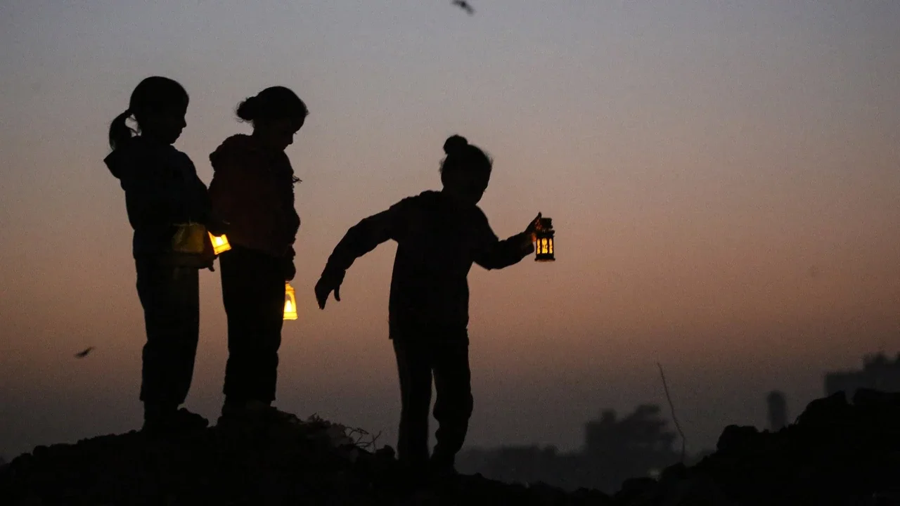 Anak-anak  bermain di reruntuhan bangunan yang hancur sambil membawa lampion Ramadan di kamp pengungsi Bureij di Jalur Gaza tengah  Minggu (15/02/2026).