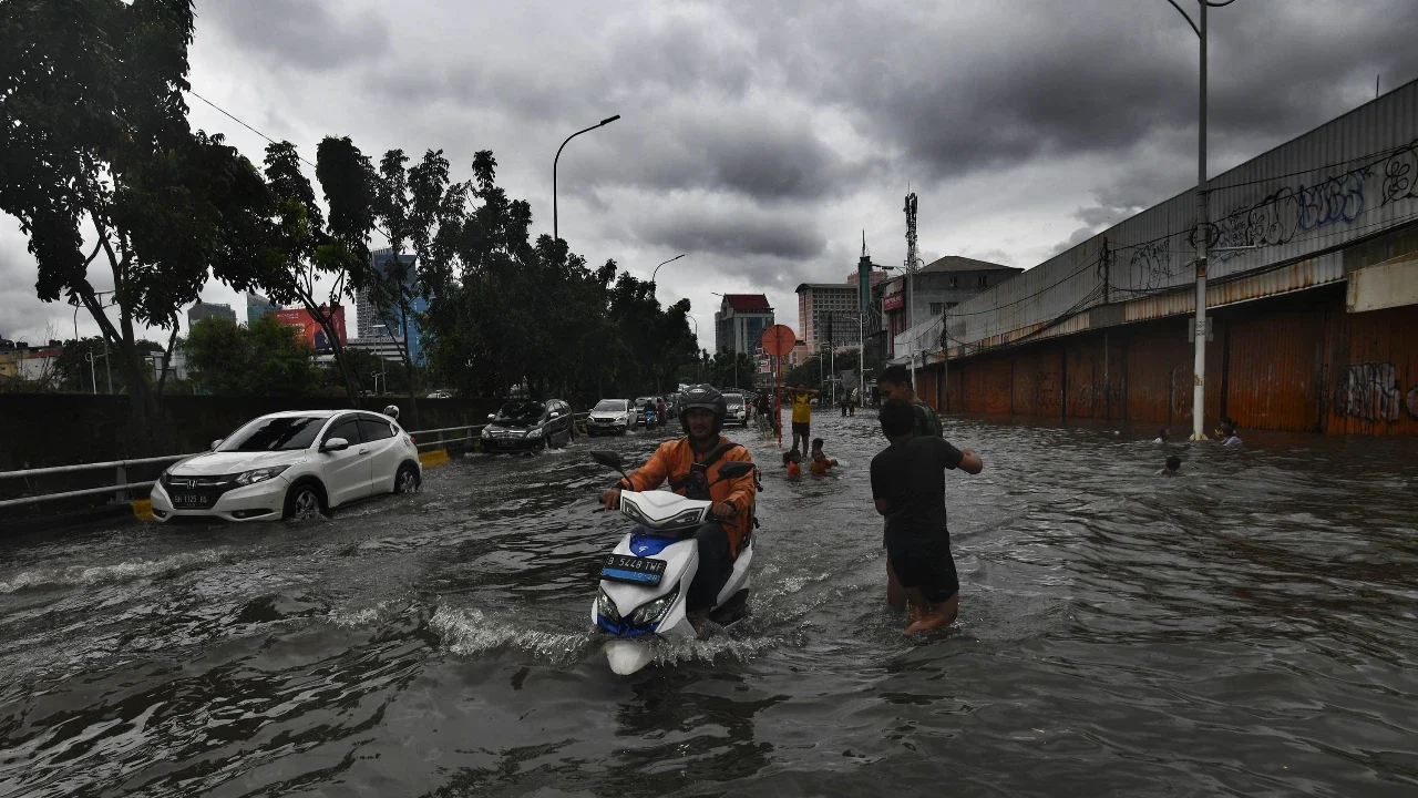 Bus TransJakarta melewati banjir yang merendam ruas Jalan Satria, Grogol, Jakarta Barat, Rabu (29/1/2025).