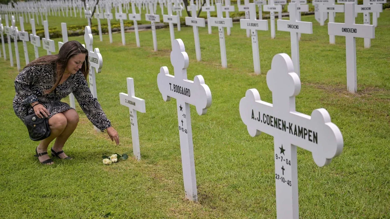 Warga meletakkan bunga Mawar di makam saat prosesi peringatan Pertempuran Laut Jawa di Ereveld (Makam Kehormatan) Kembang Kuning, Surabaya, Jawa Timur, Jumat (27/2/2026).