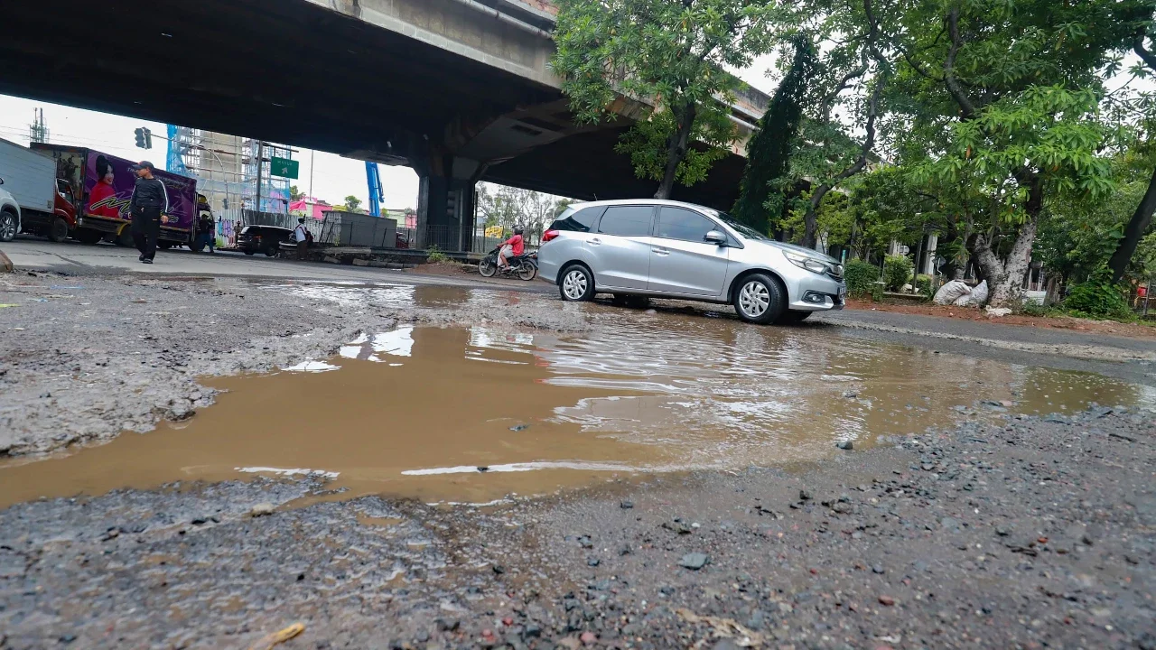 Sejumlah pengendara melewati jalan rusak  di Jalan Gedong Panjang, Penjaringan Jakarta Utara, Selasa (03/02/2026).