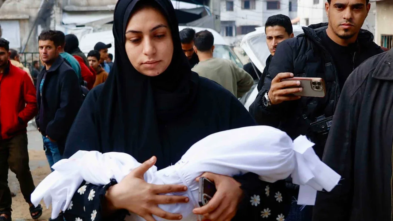 Seorang kerabat membawa jenazah Mira al-Khabbaz, bayi berusia enam bulan yang dilaporkan tewas akibat serangan Israel, keluar dari Rumah Sakit Al-Shifa, Kota Gaza, Rabu (04/02/2026).