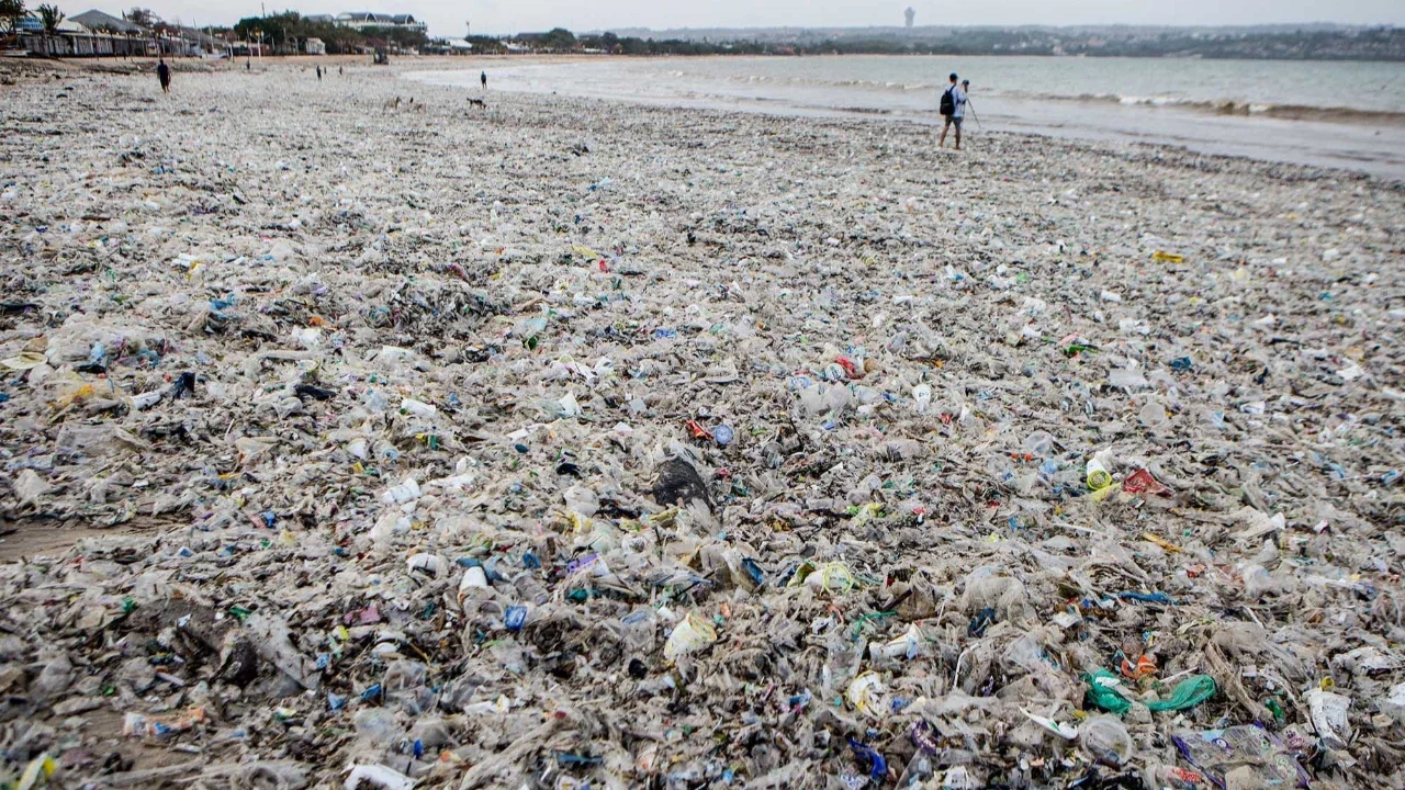 Para pekerja dan warga membersihkan puing-puing laut dan sampah plastik yang terdampar di Pantai Jimbaran, Bali,  Selasa (10/03/2026).