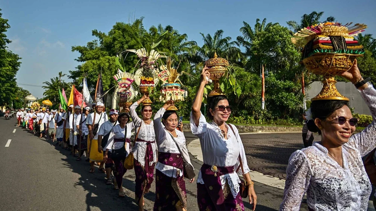 Umat Hindu berjalan dengan membawa benda sakral menuju lokasi upacara Melasti di Pantai Kenjeran, Surabaya, Jawa Timur, Sabtu (14/3/2026).