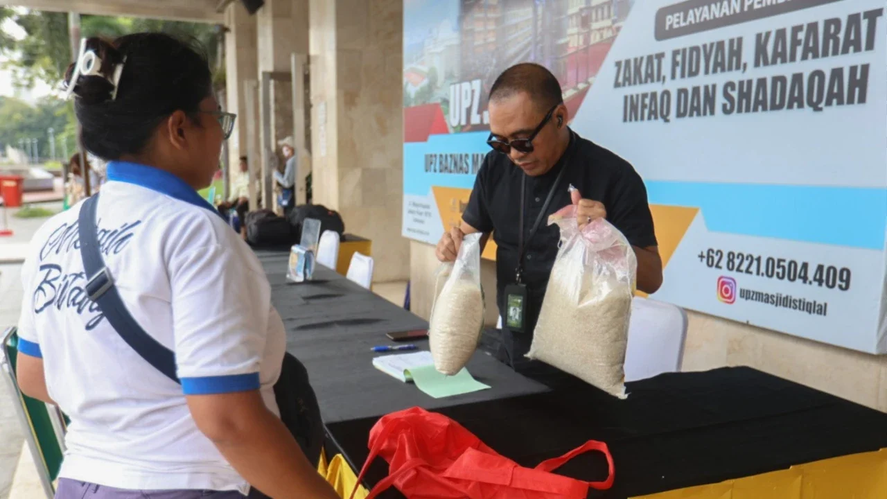Seorang amil zakat melayani muzakki yang akan membayar zakat fitrah di Masjid Istiqlal, Jakarta, Minggu (15/03/2026).