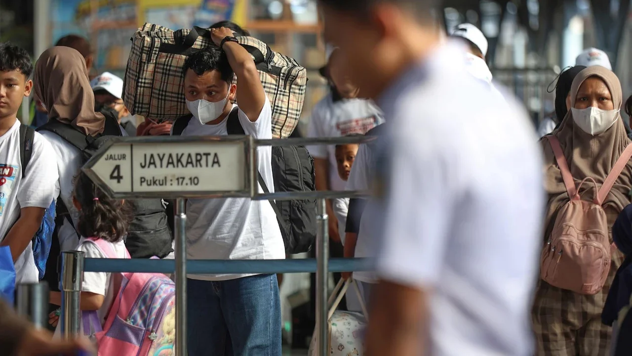 Pemudik tujuan Surabaya berjalan menuju gerbong kereta Jayakarta di Stasiun Senen, Jakarta, Senin (16/01/2026).