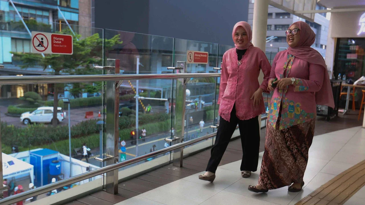 Pekerja wanita dengan mengenakan kebaya berjalan pulang kantor di kawasan Bunderan HI, Jakarta, Selasa (21/04/2026).
