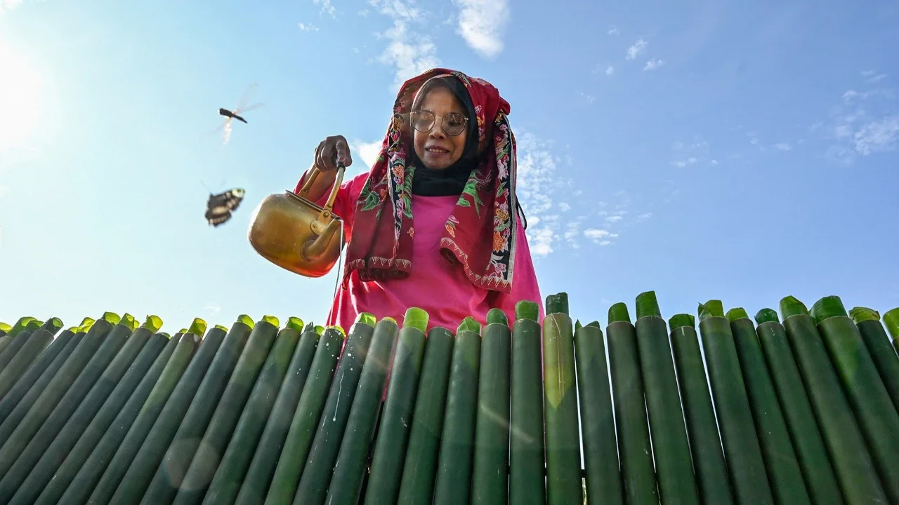 Peserta menuangkan santan ke dalam bambu saat proses memasak lemang (theut leumang) di bantaran sungai Desa Lhueng Asan, Aceh Barat Daya (Abdya), Aceh, Sabtu (25/4/2026).