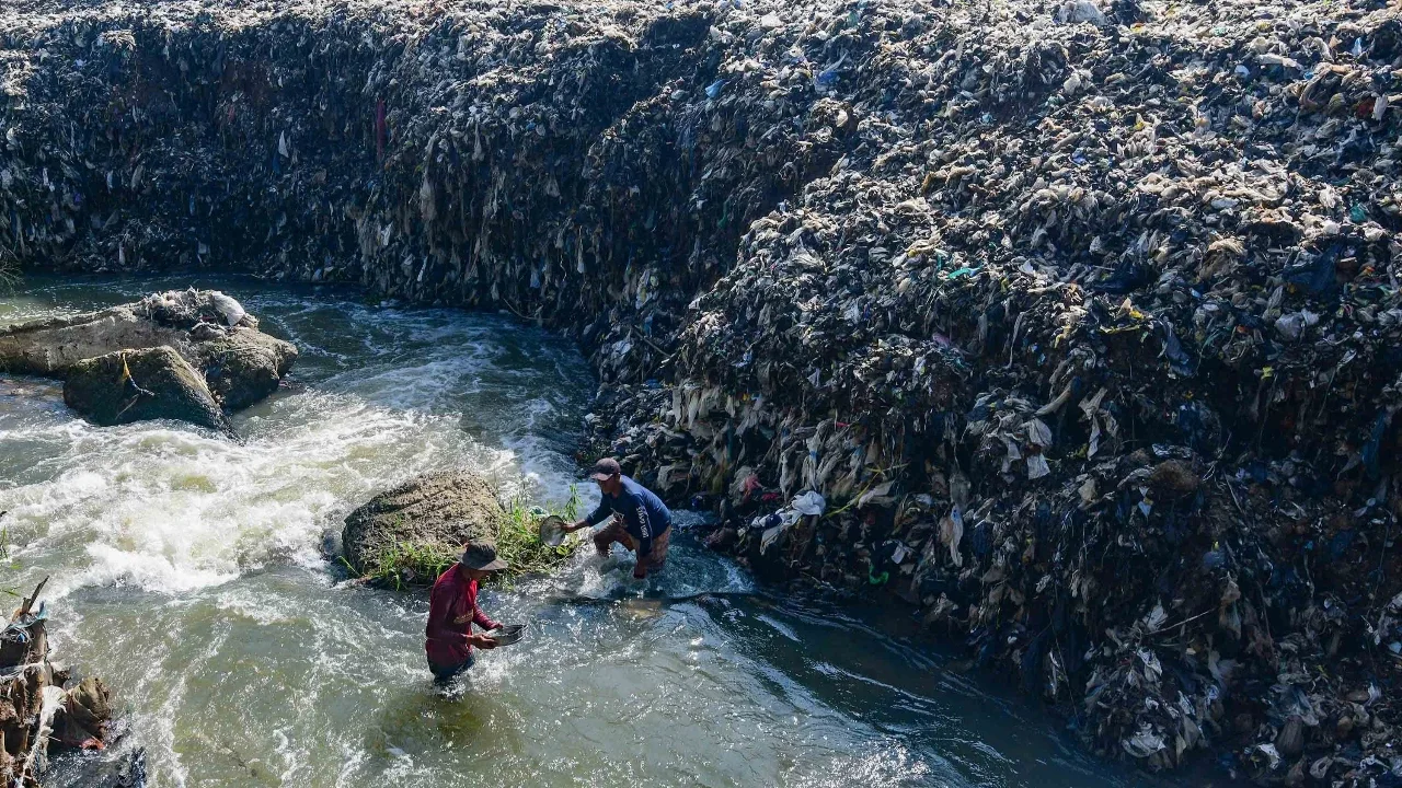 Warga mendulang benda-benda logam pada aliran Kali Pesanggrahan yang menyempit alibat longsoran timbunan sampah TPA Cipayung di kawasan Pasir Putih, Depok, Jawa Barat, Senin (27/04/2026).