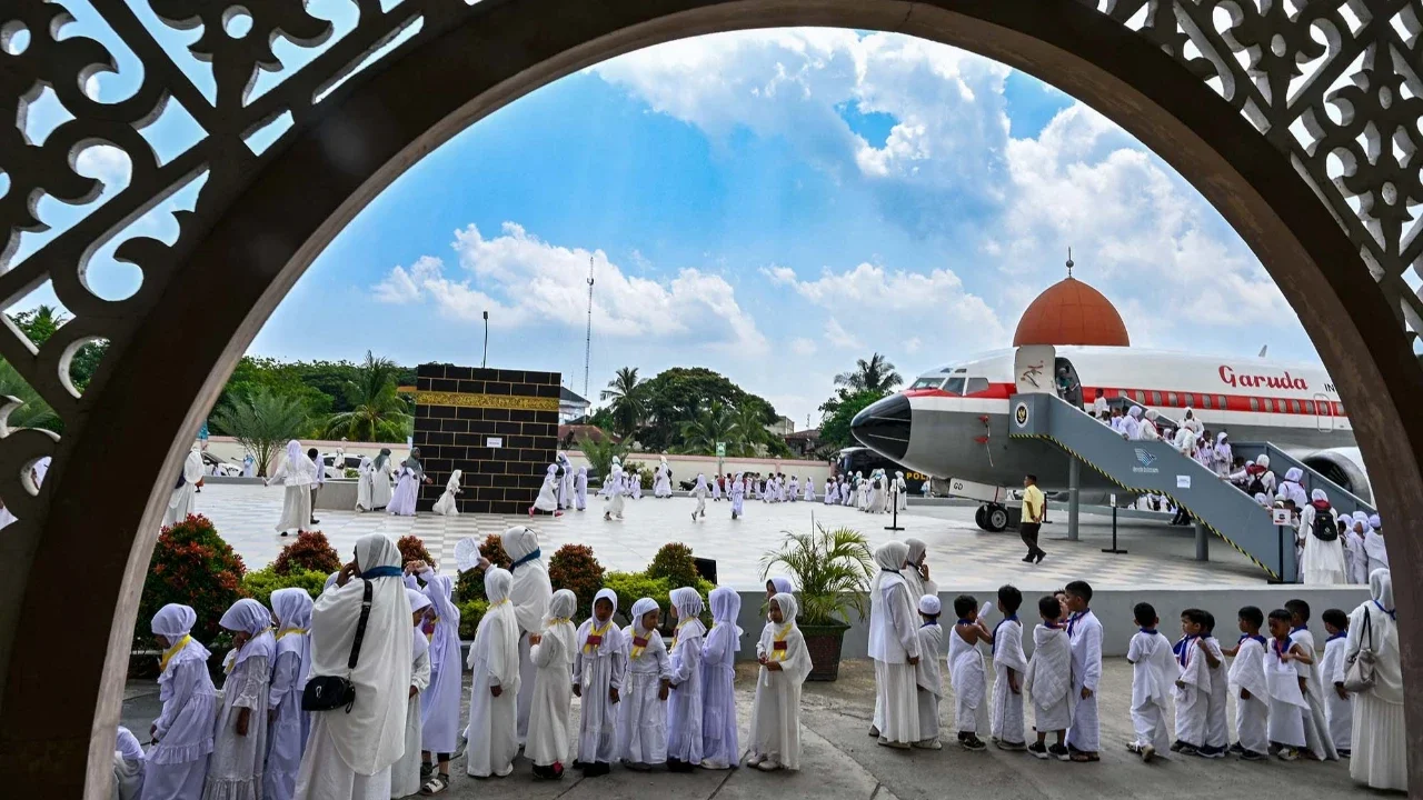 Para siswa dan guru taman kanak-kanak berlatih ritual tawaf mengelilingi replika Ka'bah di pusat ibadah haji di Banda Aceh,  Senin (27/04/2026).