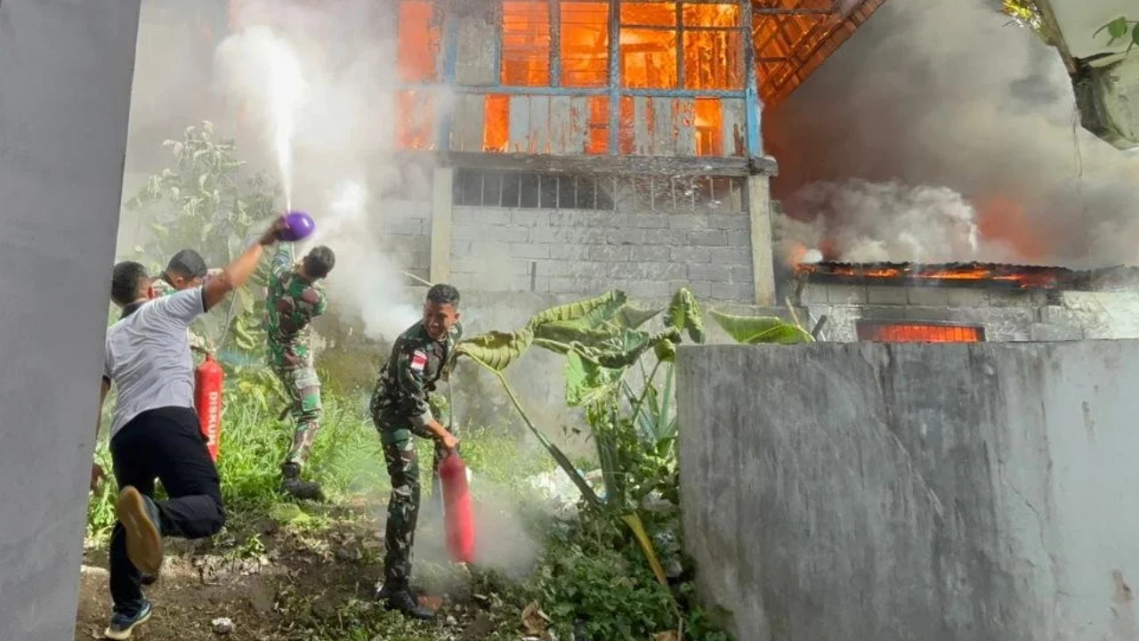 Prajurit TNI Angkatan Laut dari Kodaeral VIII bersama petugas dan warga memadamkan kebakaran di permukiman Kelurahan Kairagi Weru, Kota Manado, Selasa (28/4/2026).