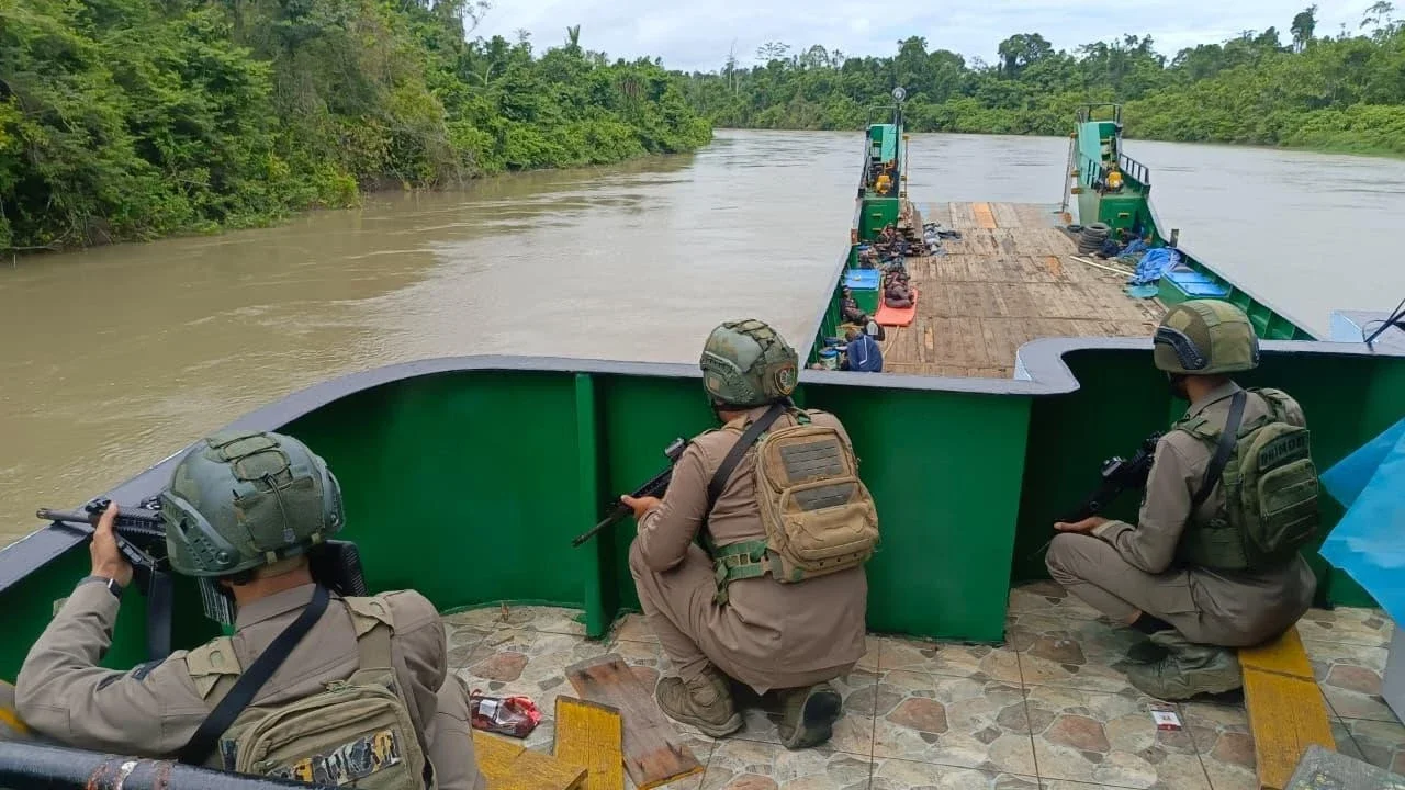 Personel Satgas Operasi Damai Cartenz 2026 bersama Polres Yahukimo mengawal enam kapal pengangkut bahan bakar minyak dan bahan makanan saat tiba di  Distrik Kolof Brazai, Kabupaten Yahukimo, Papua Pegunungan, Sabtu (9/5/2026).