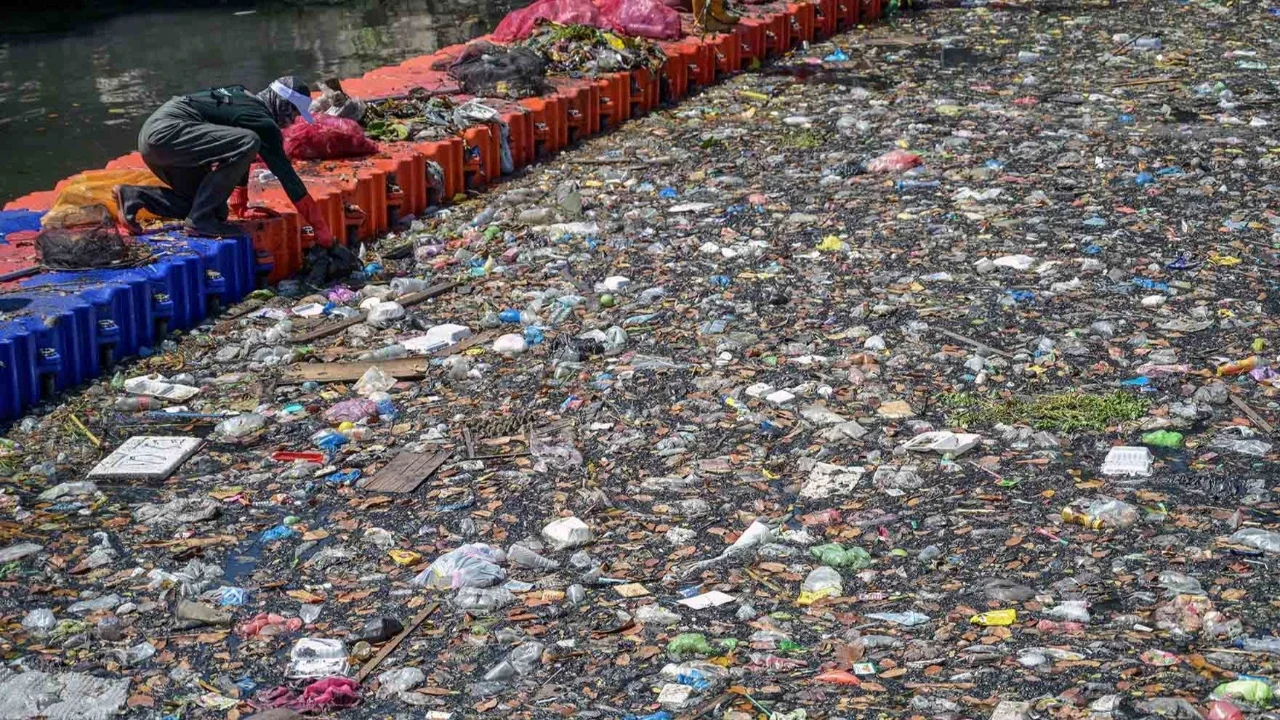 Aktivis dari ECOTON (Pengamatan Ekologi dan Konservasi Lahan Basah) dan pekerja dari Dinas Lingkungan Hidup pemerintah kota membersihkan sampah dari Sungai Kali Tebu di Surabaya, Provinsi Jawa Timur, Indonesia, Senin (11/05/2026).