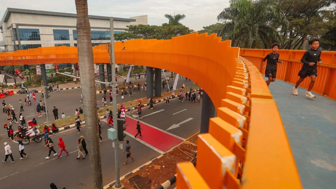 Warga beraktivitas pada Jembatan Penyeberangan Orang (JPO) Jalan Tegar Beriman, Cibinong, Kabupaten Bogor, Jawa Barat, Minggu (14/6/2026).