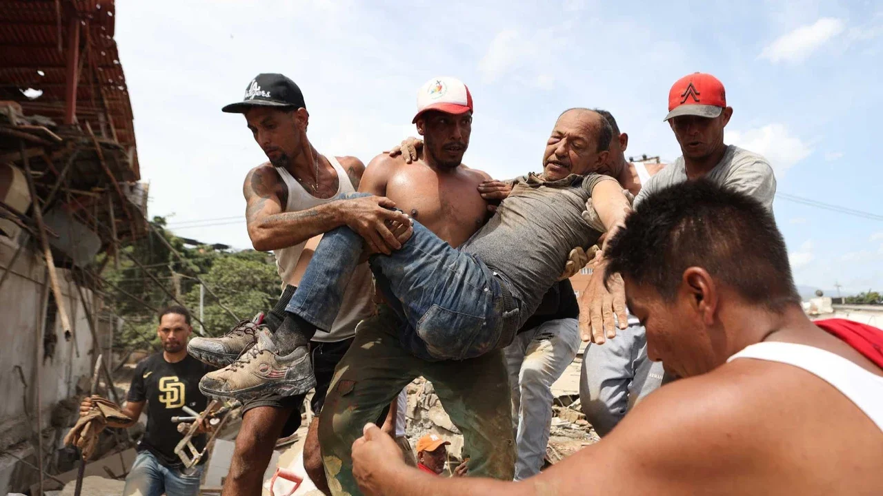 Warga sekitar menggendong seorang pria yang diselamatkan dari reruntuhan bangunan yang runtuh sehari setelah gempa bumi melanda La Guaira, Venezuela, Kamis (25/06/2026).