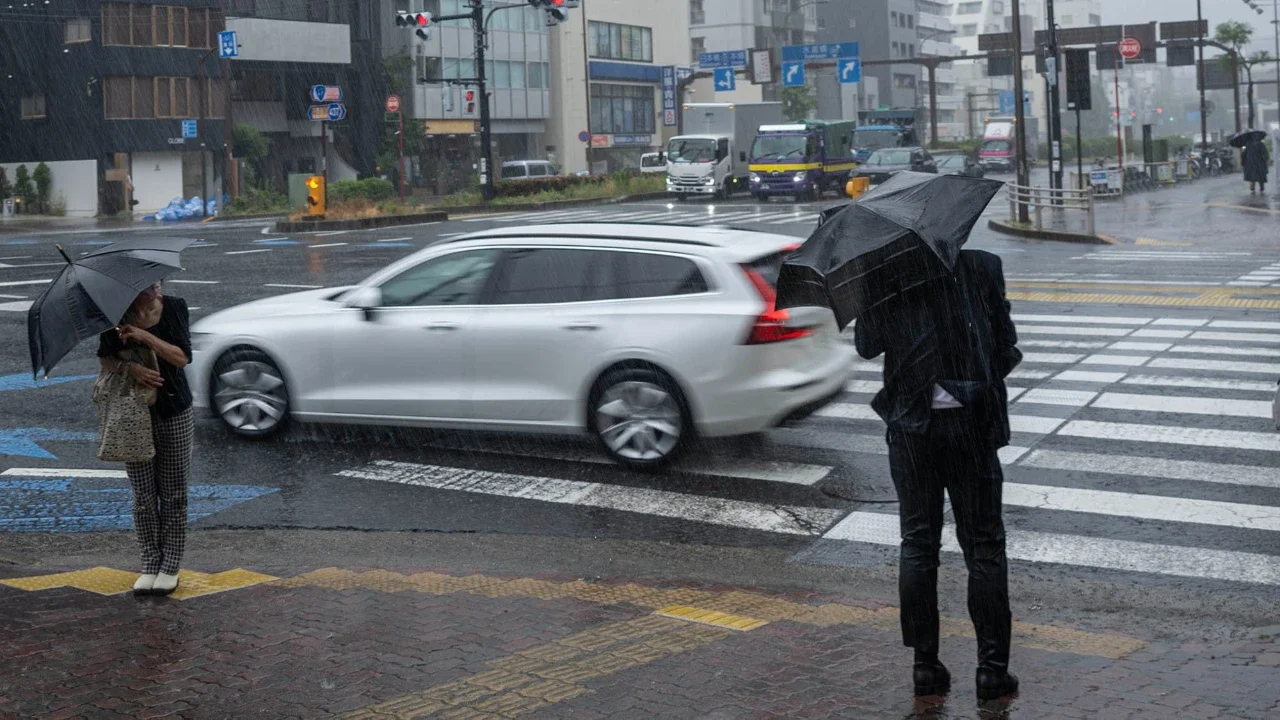 Orang-orang beraktivitas di tengah hujan deras akibat badai tropis dahsyat Jangmi di Tokyo, Rabu (03/06/2026).
