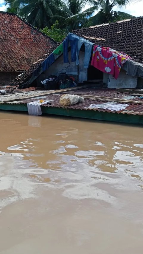 Korban banjir memanfaatkan atap rumah untuk menjemur pakaian