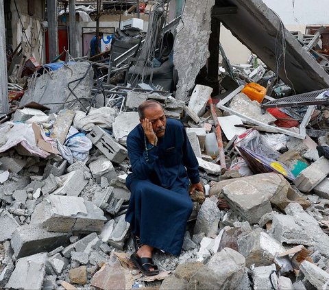 Seorang pria duduk di atas puing-puing bangunan rumahnya yang runtuh akibat gempuran Israel di Rafah, Jalur Gaza, Palestina, pada Senin (9/10/2023). Gempuran Israel untuk membalas serangan Hamas menyisakan duka mendalam bagi warga Jalur Gaza.