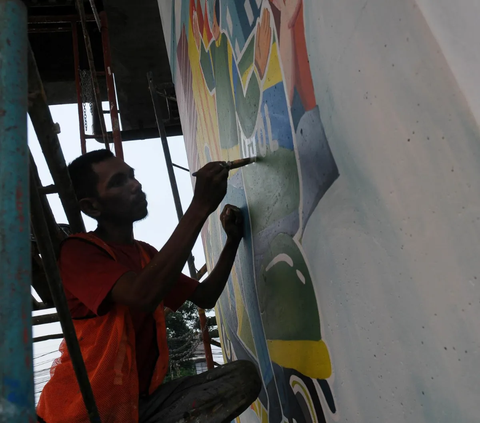 Pegiat seni lukis Jakarta Mural menyelesaikan pembuatan mural BPJS Ketenagakerjaan (BPJAMSOSTEK) yang menghiasi Kolong Tol Becakayu di Jakarta, Kamis (12/10/2023).