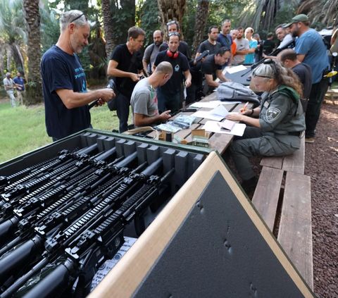 Warga Israel mendaftar diri mereka untuk mendapatkan senjata bagi yang diizinkan di Ayyelet HaShahar Kibbutz, di Israel utara, dekat perbatasan Lebanon, Kamis (12/10/2023).<br>