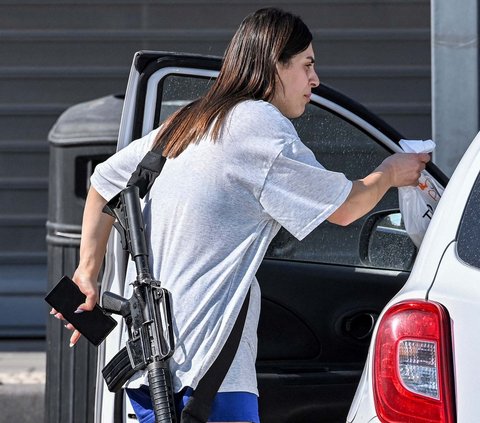 Wanita itu diduga berbelanja sambil membawa senapan serbu M16 untuk berjaga-jaga jika terjadi serangan dari kelompok Hamas.