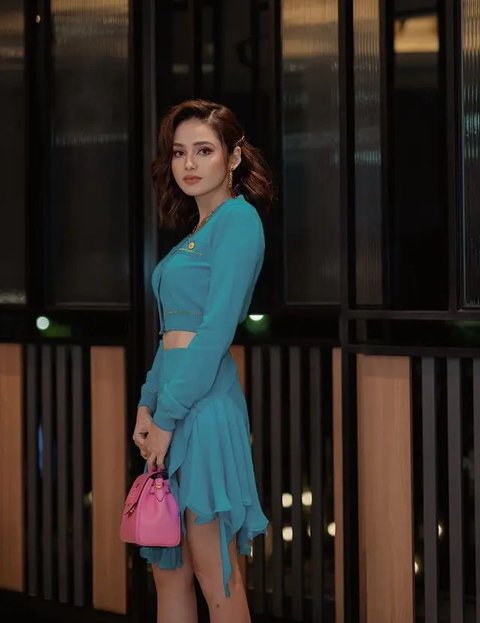 Syifa tampil dengan pakaian hijau dari Versace dan membawa tas pink.<br>