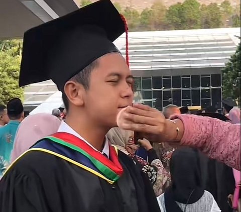 Tak Malu, Mahasiswa Ini Anteng Saat Dibedaki Sang Ibu di Depan Teman Jelang Acara Wisuda