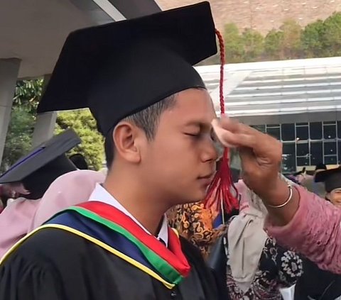 Tak Malu, Mahasiswa Ini Anteng Saat Dibedaki Sang Ibu di Depan Teman Jelang Acara Wisuda