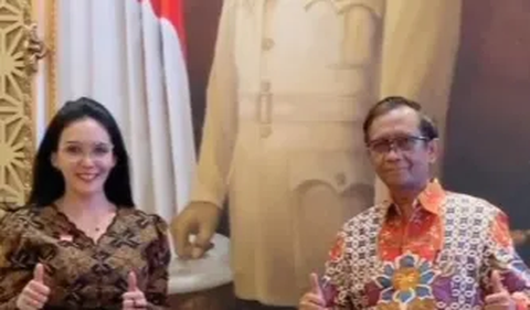 Mereka berfoto di sebuah ruangan dan di depan lukisan raksasa Presiden pertama RI Soekarno.