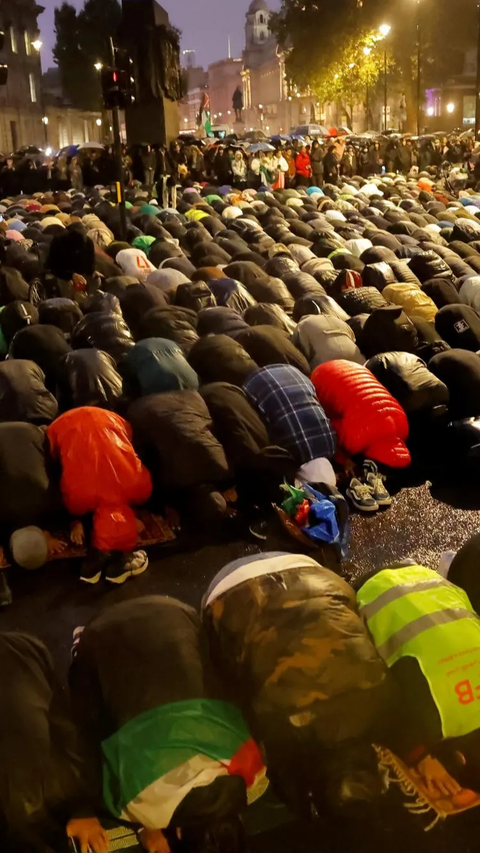 Dalam aksi di tengah guyuran hujan, warga muslim London menggelar salat gaib berjemaah di tengah jalan.<br>