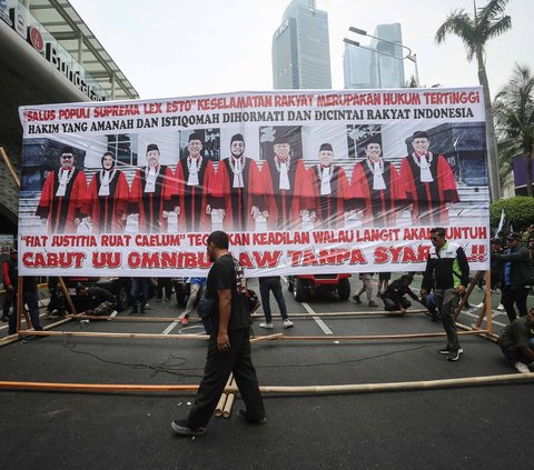 Massa demonstran yang tergabung dalam Gerakan Buruh Bersama Rakyat (GEBRAK) menggelar aksi turun ke jalan di kawasan Patung Kuda, Jakarta, Senin (2/10/2023).