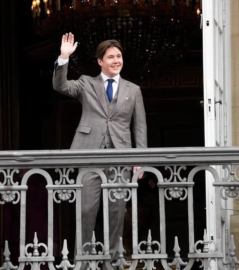 Di hari spesial ini, Pangeran Christian tampil di balkon dengan gaya yang keren: setelan jas abu-abu, dasi biru, dan kemeja putih.