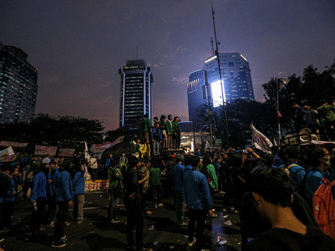 FOTO: Hingga Malam Hari Massa BEM SI Masih Bertahan dan Gelar Aksi Bakar Ban di Kawasan Patung Kuda