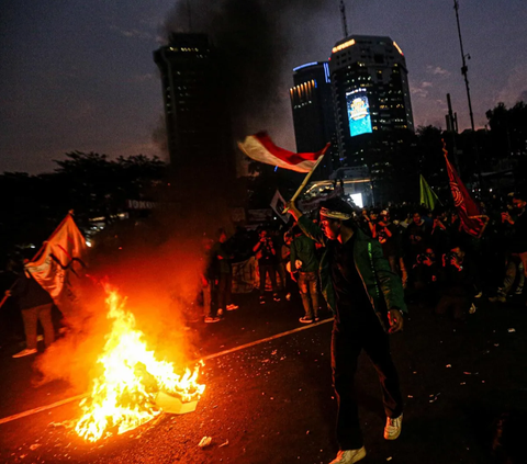 FOTO: Hingga Malam Hari Massa BEM SI Masih Bertahan dan Gelar Aksi Bakar Ban di Kawasan Patung Kuda