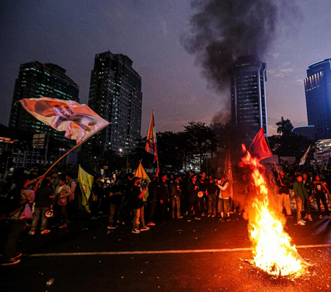 FOTO: Hingga Malam Hari Massa BEM SI Masih Bertahan dan Gelar Aksi Bakar Ban di Kawasan Patung Kuda