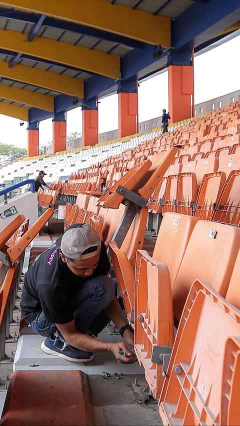 Pekerja melaukan pemasangan kursi penonton pada tribun Stadion Si Jalak Harupat.