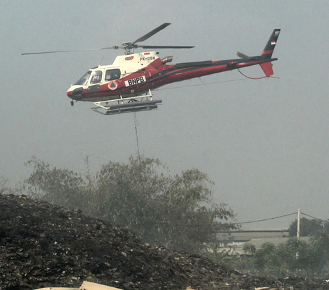 Helikopter Water Bombing  Badan Nasional Penanggulangan Bencana (BNPB) masih terus melakukan pemadaman api yang membakar tempat pembuangan akhir (TPA) Rawa Kucing, Neglasari, Kota Tangerang, Senin (23/10/2023).